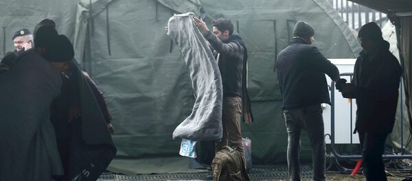 Migrants wait for transport to Slovenia after they registered at a new winter refugee camp in Slavonski Brod, Croatia - Sputnik International