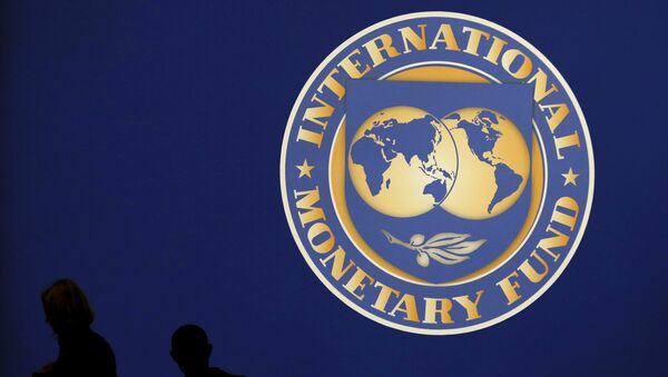 Visitors are silhouetted against the logo of the International Monetary Fund at the main venue for the IMF and World Bank annual meeting in Tokyo in this October 10, 2012 file photo. - Sputnik International