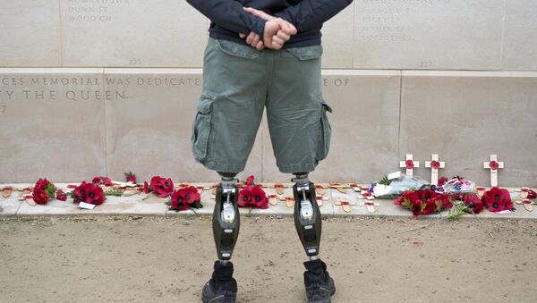 A member of the armed forces with prosthetic legs pays his respects at the Armed Forces Memorial in the National Memorial Arboretum on Armistice Day near Lichfield, Staffordshire, central England, on November 11, 2014. - Sputnik International