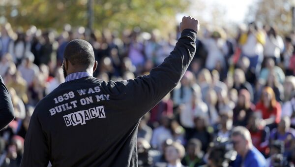 A member of the black student protest group Concerned Student 1950 gestures while addressing a crowd following the announcement that University of Missouri System President Tim Wolfe would resign Monday, Nov. 9, 2015, at the university in Columbia, Mo. Wolfe resigned Monday with the football team and others on campus in open revolt over his handling of racial tensions at the school. - Sputnik International