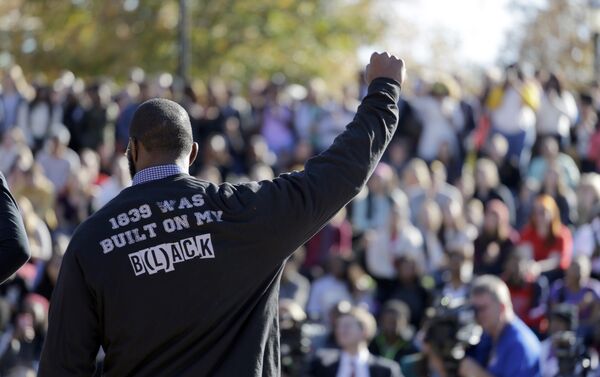 A member of the black student protest group Concerned Student 1950 gestures while addressing a crowd following the announcement that University of Missouri System President Tim Wolfe would resign Monday, Nov. 9, 2015, at the university in Columbia, Mo. Wolfe resigned Monday with the football team and others on campus in open revolt over his handling of racial tensions at the school. - Sputnik International