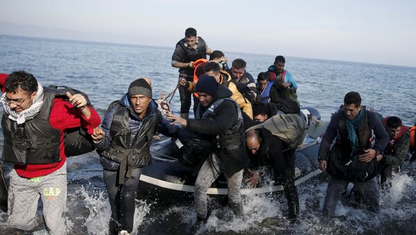Refugees and migrants jump off an inflatable raft as they arrive on the Greek island of Lesbos, November 11, 2015 - Sputnik International