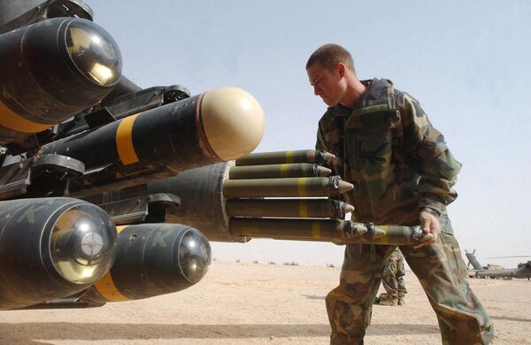 US Army armament crew specialist Michael Mayo, from Florida, loads the rocket pod of an an Apache AH-64D attack helicopter also armed with Hellfire missiles at left US Army armament crew specialist Michael Mayo, from Florida, loads the rocket pod of an an Apache AH-64D attack helicopter also armed with Hellfire missiles at left - Sputnik International