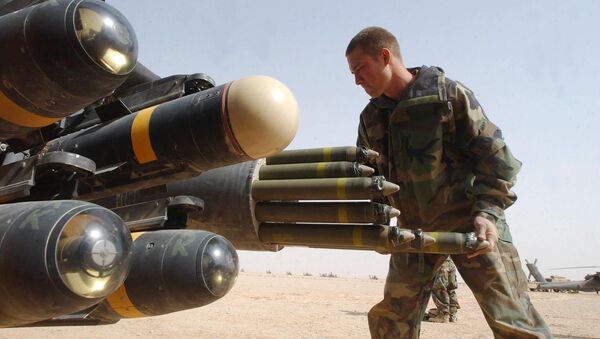 US Army armament crew specialist Michael Mayo, from Florida, loads the rocket pod of an an Apache AH-64D attack helicopter also armed with Hellfire missiles at left - Sputnik International