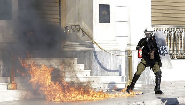 A riot policeman tries to avoid a petrol bomb thrown by protesters during a rally in Athens, Thursday, Nov. 12, 2015. - Sputnik International