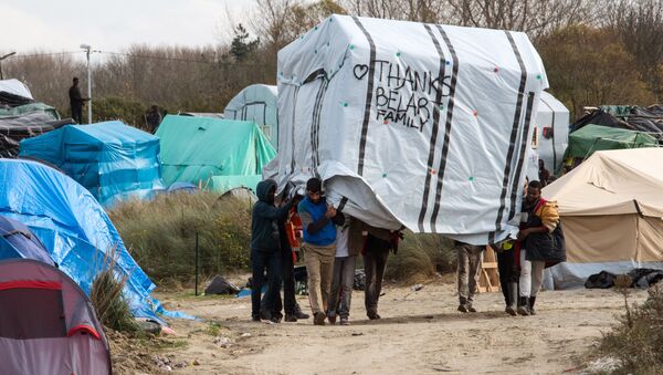 Migrant men move a tent in the New Jungle migrant camp in Calais on November 12, 2015. - Sputnik International