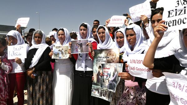 Yazidi Kurdish women hold posters during a protest against the Islamic State group's invasion on Sinjar city one year ago, in Dohuk, northern Iraq. - Sputnik International