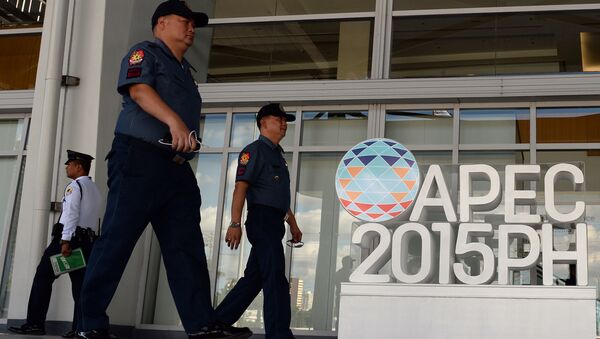 Philippine policemen walk past an Asia Pacific Economic Cooperation (APEC) summit logo in front of the media centre in Manila on November 11, 2015 - Sputnik International