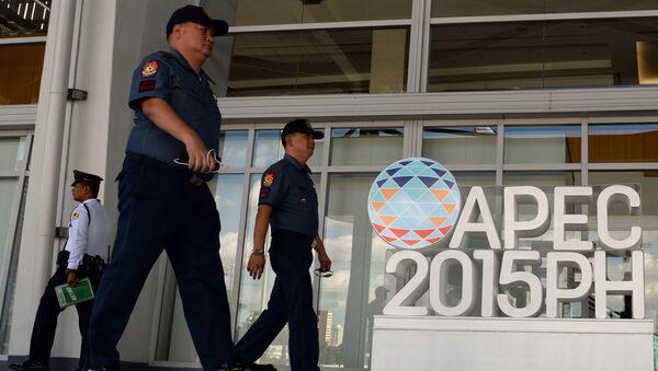 Philippine policemen walk past an Asia Pacific Economic Cooperation (APEC) summit logo in front of the media centre in Manila - Sputnik International