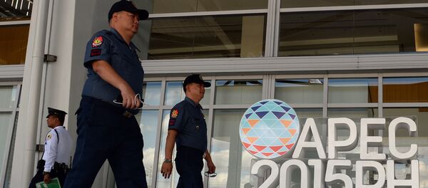 Philippine policemen walk past an Asia Pacific Economic Cooperation (APEC) summit logo in front of the media centre in Manila Philippine policemen walk past an Asia Pacific Economic Cooperation (APEC) summit logo in front of the media centre in Manila - Sputnik International
