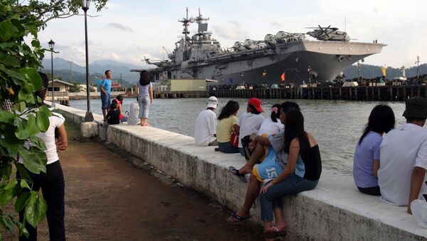 People stand near the docked amphibious assault ship USS Essex at Subic Bay, Philippines. - Sputnik International
