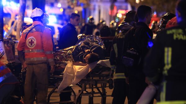 A person is being evacuated after a shooting, outside the Bataclan theater in Paris, Friday Nov. 13, 2015.  - Sputnik International