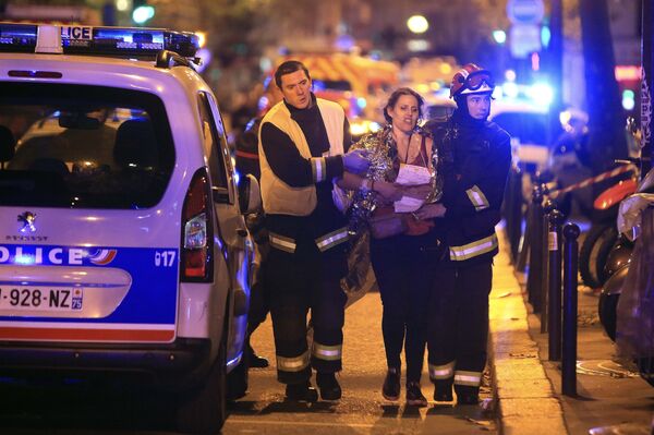 Rescue workers help a woman after a shooting, outside the Bataclan theater in Paris, Friday Nov. 13, 2015. Rescue workers help a woman after a shooting, outside the Bataclan theater in Paris, Friday Nov. 13, 2015. - Sputnik International