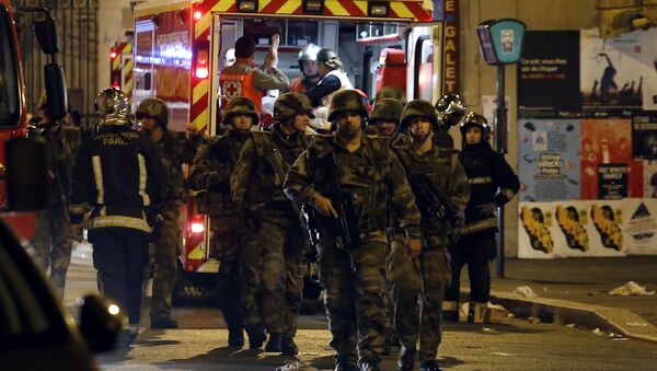 Soldiers walk in front of an ambulance as rescue workers evacuate victims near La Belle Equipe, rue de Charonne, at the site of an attack on Paris on November 14, 2015 - Sputnik International