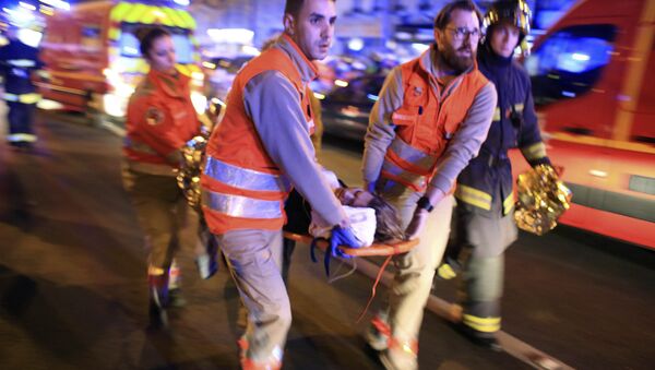 A woman is being evacuated from the Bataclan theater after a shooting in Paris, Friday Nov. 13, 2015 - Sputnik International