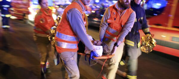 A woman is being evacuated from the Bataclan theater after a shooting in Paris, Friday Nov. 13, 2015 - Sputnik International