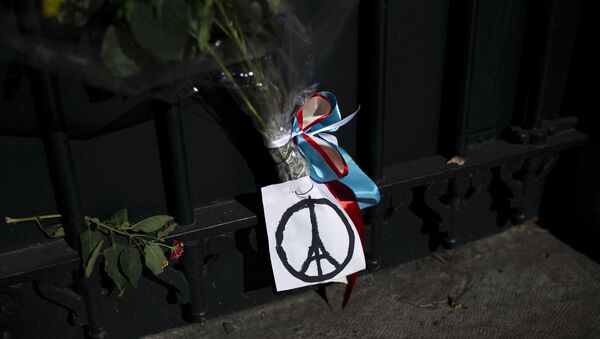 Flowers and a peace sign in the shape of the Parisian landmark the Eiffel Tower, are seem outside French Embassy in Greece on November 14, 2015, a day after deadly attacks in Paris - Sputnik International