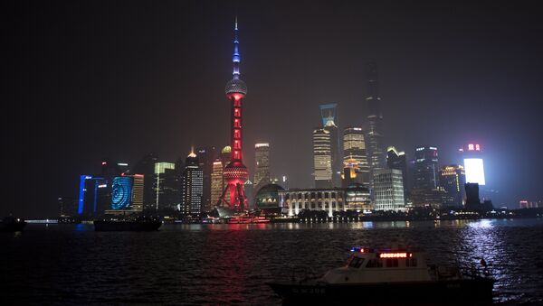 The Oriental Pearl TV Tower (C), in the Lujiazui Financial District in Pudong, is lit in red, white and blue, resembling the colours of the French flag, in Shanghai on November 14, 2015 - Sputnik International