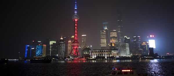 The Oriental Pearl TV Tower (C), in the Lujiazui Financial District in Pudong, is lit in red, white and blue, resembling the colours of the French flag, in Shanghai on November 14, 2015 - Sputnik International