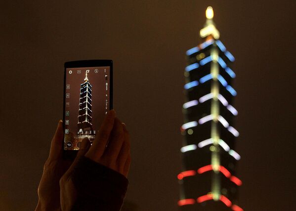 Taiwan’s supertall Taipei 101 skyscraper lit in French red-white-and-blue colors to commemorate the victims of the November 13th Paris deadly terrorist attacks. - Sputnik International
