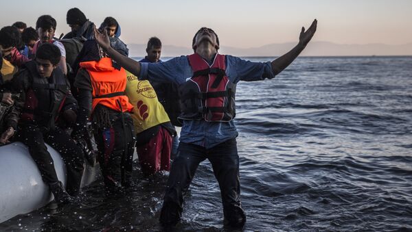 A young man gestures after disembarking from a dinghy at a beach on the Greek island of Lesbos after crossing the Aegean sea from the Turkish coast, Saturday, Nov. 14, 2015 - Sputnik International