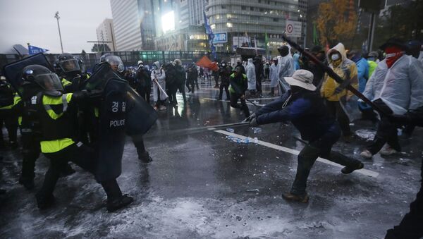 South Korean riot police officers spray water cannons to try to break up protesters who tried to march to the Presidential House after a rally against government policy in Seoul, South Korea, Saturday, Nov. 14, 2015 - Sputnik International