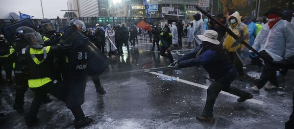 South Korean riot police officers spray water cannons to try to break up protesters who tried to march to the Presidential House after a rally against government policy in Seoul, South Korea, Saturday, Nov. 14, 2015 - Sputnik International