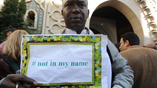 File photo of a man holds a placard reading Not in my name during a demonstration called by muslims groups to denounce the barbarism of Islamic State militants, on September 26, 2014 outside Paris's main mosque - Sputnik International