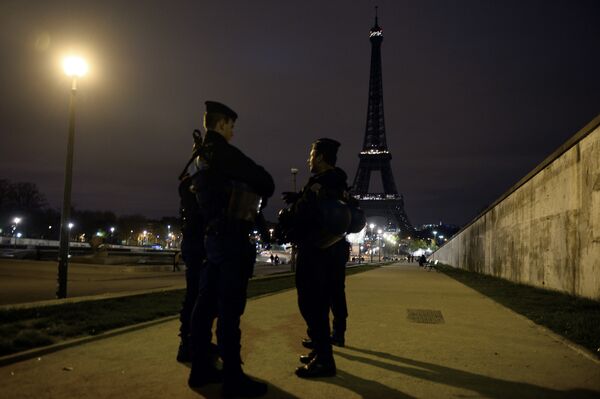 Police officers stand guard near the Eiffel Tower which has its lights turned off on November 14, 2015 following the deadly attacks in Paris. Police officers stand guard near the Eiffel Tower which has its lights turned off on November 14, 2015 following the deadly attacks in Paris. - Sputnik International