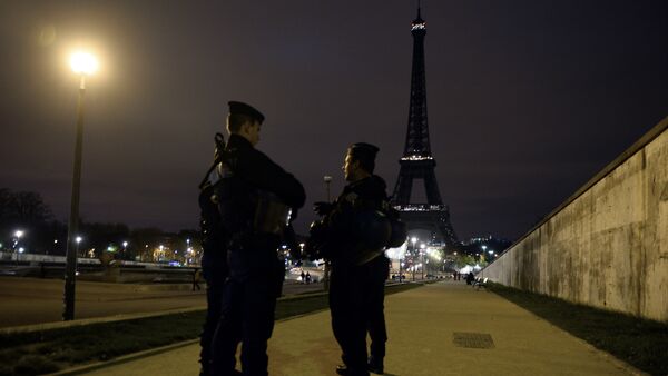Police officers stand guard near the Eiffel Tower which has its lights turned off on November 14, 2015 following the deadly attacks in Paris. - Sputnik International