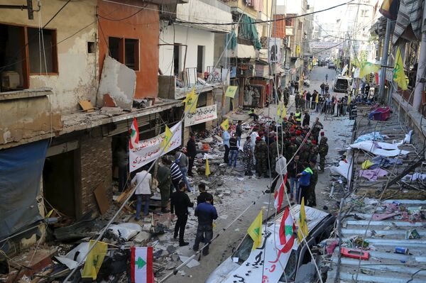 Lebanese army soldiers and security forces gather as Lebanese and Hezbollah flags are erected at the site of the two explosions that occured on Thursday in the southern suburbs of the Lebanese capital Beirut, November 13, 2015 Lebanese army soldiers and security forces gather as Lebanese and Hezbollah flags are erected at the site of the two explosions that occured on Thursday in the southern suburbs of the Lebanese capital Beirut, November 13, 2015 - Sputnik International