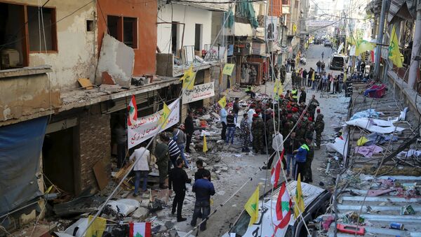 Lebanese army soldiers and security forces gather as Lebanese and Hezbollah flags are erected at the site of the two explosions that occured on Thursday in the southern suburbs of the Lebanese capital Beirut, November 13, 2015 - Sputnik International