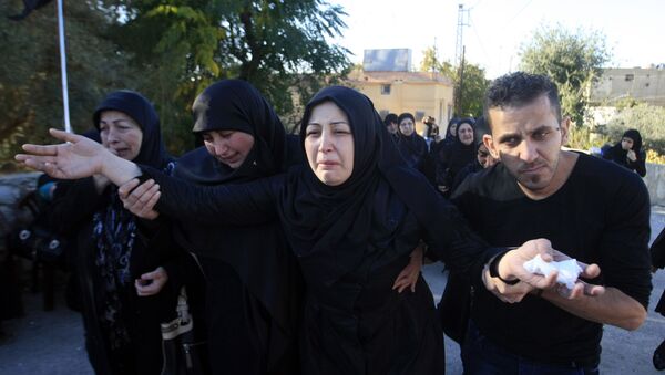 Zahraa al-Athath, second right, wife of Hezbollah member Adel Termos, who was killed in Thursday's twin suicide bombings, mourns during his funeral procession in the southern Lebanese village of Tallousa, Lebanon, Friday, Nov. 13, 2015 - Sputnik International