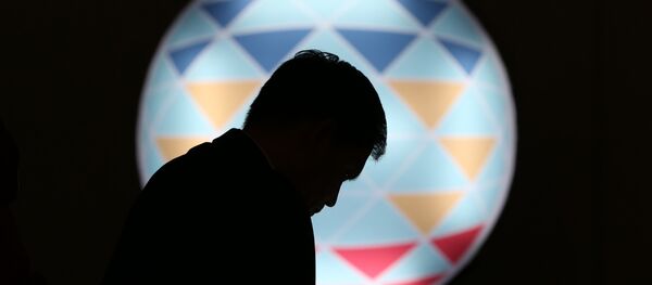 FILE - In this Sunday, Nov. 15, 2015, file photo, a Filipino checks his smartphone in front of the logo of APEC 2015 in Manila, Philippines - Sputnik International
