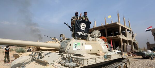 Iraqi Shiite fighters from the Popular Mobilisation units, fighting alongside Iraqi government forces, display, upside down, the flag of the Islamic State (IS) group during a military operation aimed at the centre of Baiji, some 200 kilometres north of Baghdad on October 19, 2015 Iraqi Shiite fighters from the Popular Mobilisation units, fighting alongside Iraqi government forces, display, upside down, the flag of the Islamic State (IS) group during a military operation aimed at the centre of Baiji, some 200 kilometres north of Baghdad on October 19, 2015 - Sputnik International