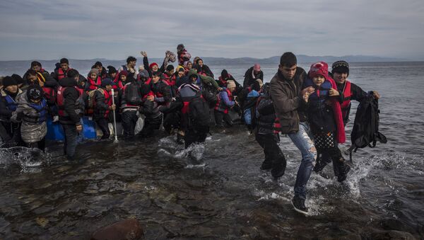 Migrants and refugees disembark safely from a dinghy at a beach on the Greek island of Lesbos after crossing the Aegean sea from the Turkish coast, Monday, Nov. 16, 2015 - Sputnik International