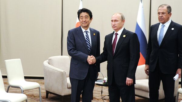Japanese Prime Minister Shinzo Abe, left, shakes hands with Russian President Vladimir Putin prior their talks during the G-20 Summit in Antalya, Turkey, Monday, Nov. 16, 2015 - Sputnik International