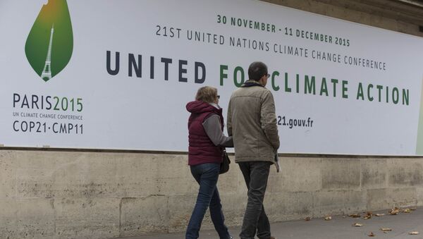 Pedestrians walk in front of posters for the COP 21 World Climate Summit in Paris, France, - Sputnik International