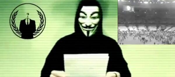 Still image from a video shows a man wearing a mask associated with Anonymous making a statement - Sputnik International