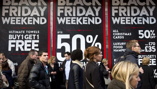 Shoppers are pictured walking past 'Black Friday' advertising in shop windows on Oxford Street in central London on November 28, 2014. - Sputnik International