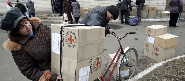 File photo of the residents of the eastern Ukrainian city of Avdiivka, in the Donetsk region controlled by Ukrainian forces, carry boxes containing Red Cross humanitarian aid in Avdiivka on March 2, 2015 - Sputnik International