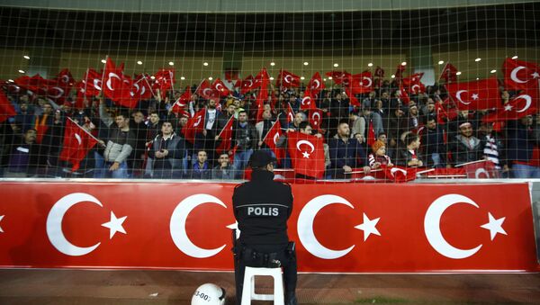 A policeman stands guard in front of supporters of Turkey during their international friendly soccer match against Greece at Basaksehir Fatih Terim stadium in Istanbul, Turkey November 17, 2015 - Sputnik International