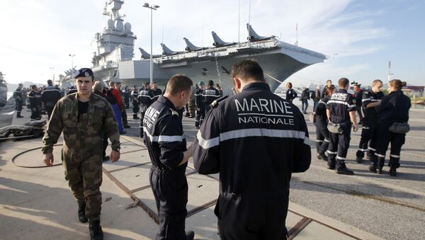 French Navy crew members walk on the docks in front of the French nuclear-powered aircraft carrier Charles de Gaulle before its departure from the naval base of Toulon, France, November 18, 2015 - Sputnik International