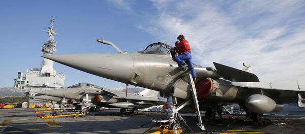Flight deck crew work on Rafale fighter jets aboard the French nuclear-powered aircraft carrier Charles de Gaulle before its departure from the naval base of Toulon, France, November 18, 2015 - Sputnik International