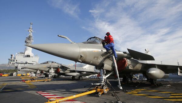 Flight deck crew work on Rafale fighter jets aboard the French nuclear-powered aircraft carrier Charles de Gaulle before its departure from the naval base of Toulon, France, November 18, 2015 - Sputnik International