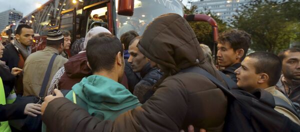 Migrants board buses after their evacuation from the Lycee Jean Quarre, an empty secondary school occupied by hundred of migrants and asylum seekers in the 19th district in Paris, France, October 23, 2015. Migrants board buses after their evacuation from the Lycee Jean Quarre, an empty secondary school occupied by hundred of migrants and asylum seekers in the 19th district in Paris, France, October 23, 2015. - Sputnik International
