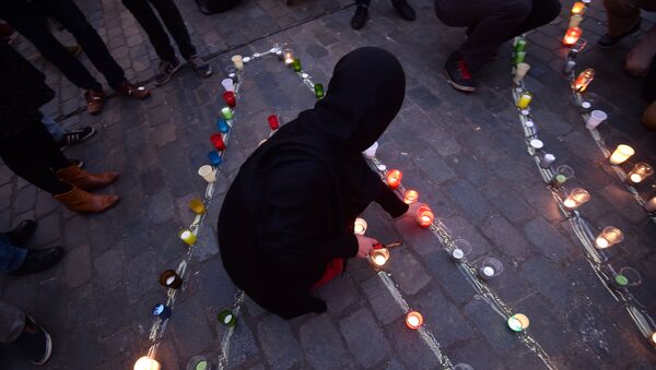 A person lights a candle during a candle light vigil to the victims of the Paris attacks in Brussels' Molenbeek district, on November 18, 2015. - Sputnik International