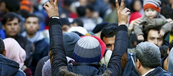 Migrants gesture after arriving at the Austrian-German border in Achleiten Migrants gesture after arriving at the Austrian-German border in Achleiten - Sputnik International