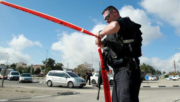 An Israeli police officer holds police tape. - Sputnik International