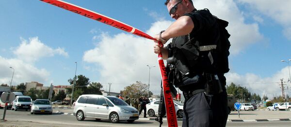 An Israeli police officer holds police tape. - Sputnik International